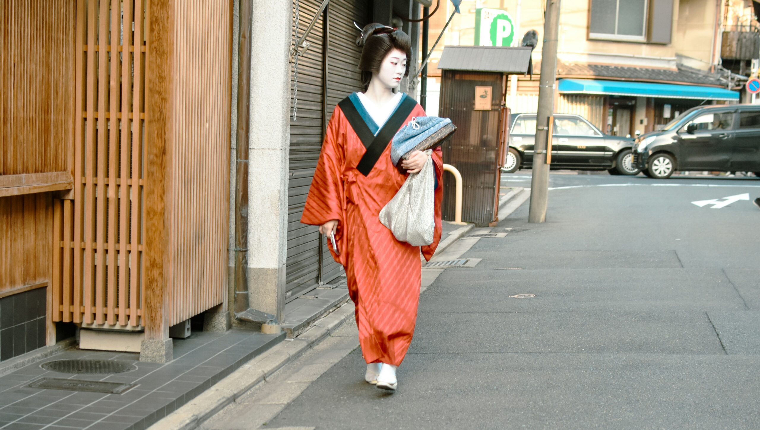 Japanese woman wearing traditional kimono standing peacefully in Kyoto temple garden with cherry blossoms and traditional architecture