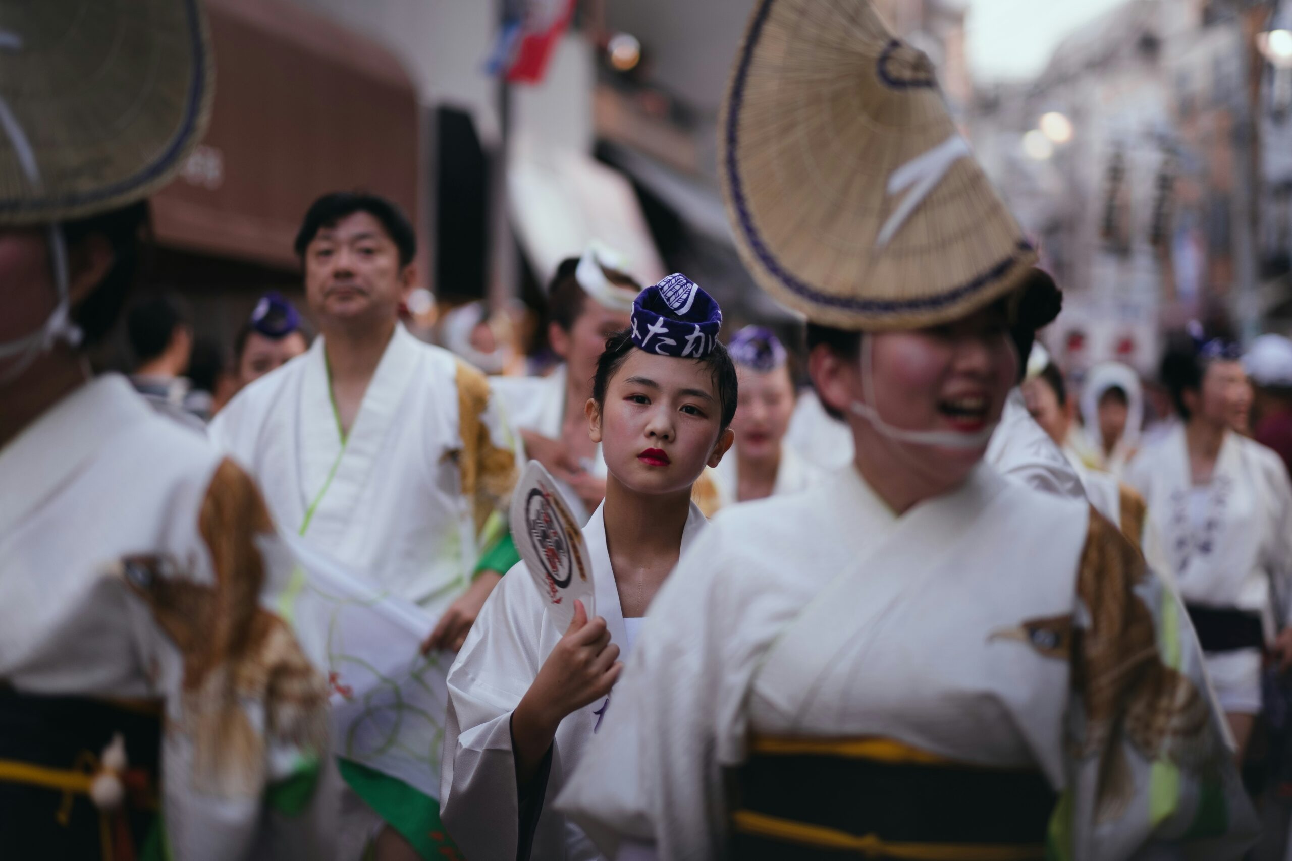 Festival participants in traditional white attire and headbands participating in a summer matsuri