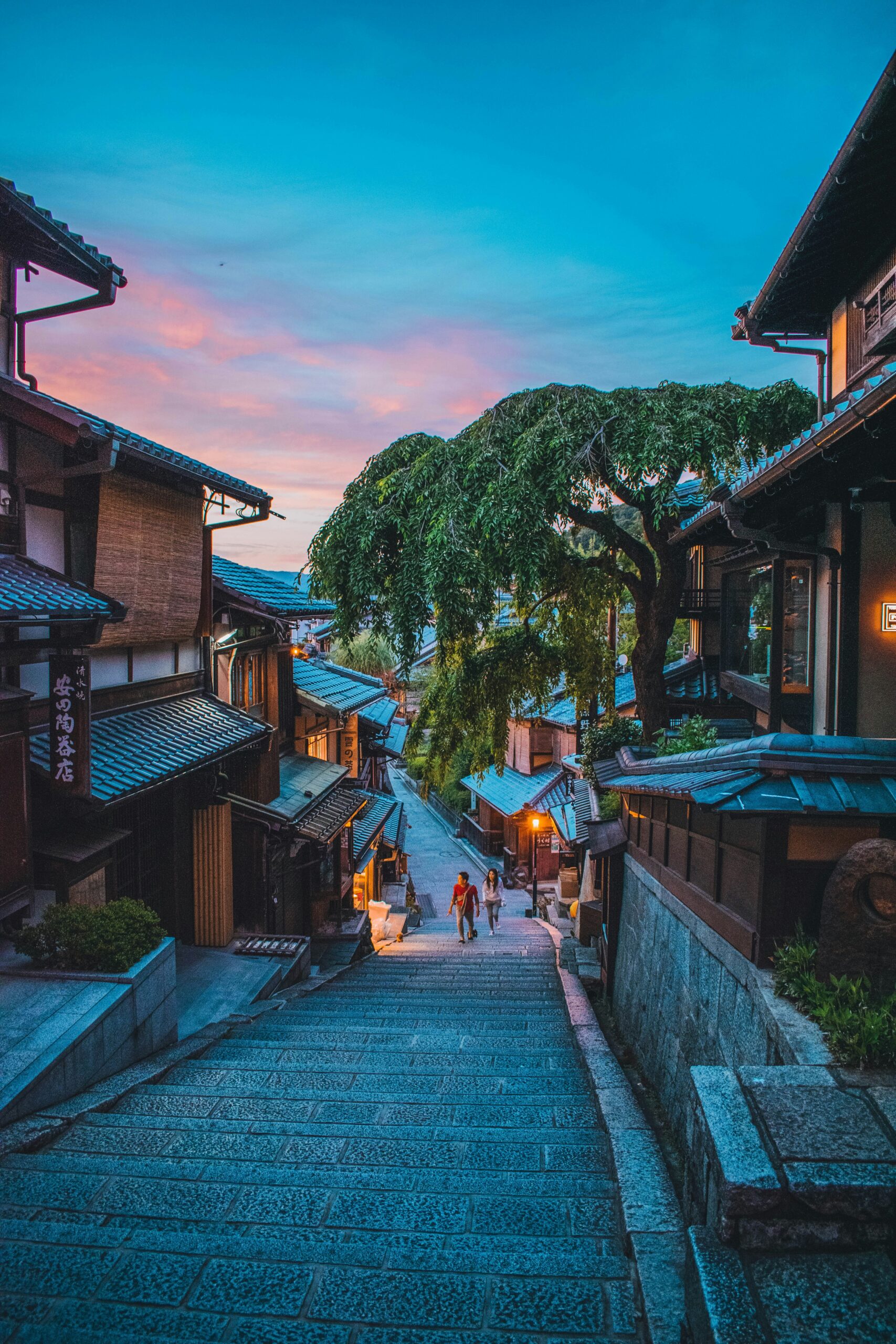 Traditional Japanese street with wooden buildings and stone steps at dusk in Kyoto