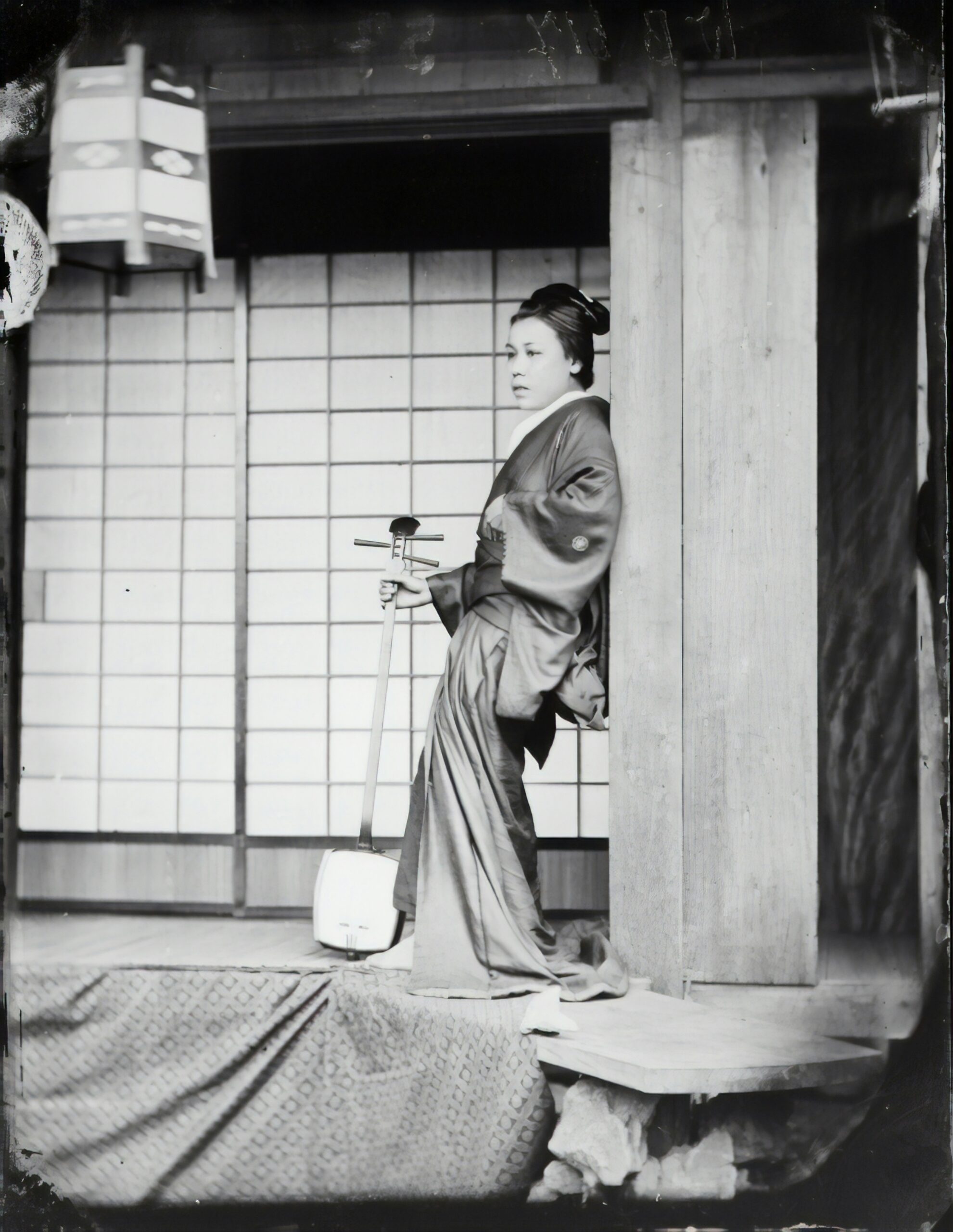 Fotografía histórica en blanco y negro de una mujer con un kimono tradicional sosteniendo una espada en una pose formal, que muestra una composición clásica de fotografía de kimono.