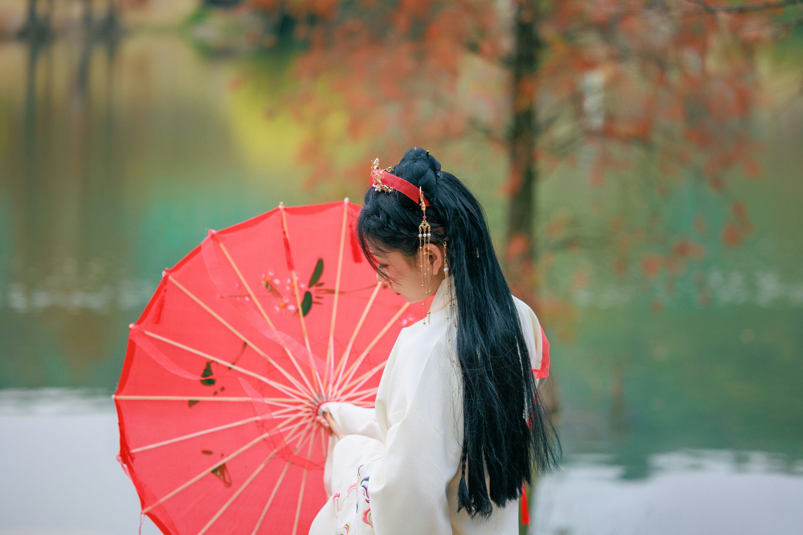 Japanese bride and groom in traditional wedding kimono posing among blooming cherry blossom trees in Kyoto spring garden setting
