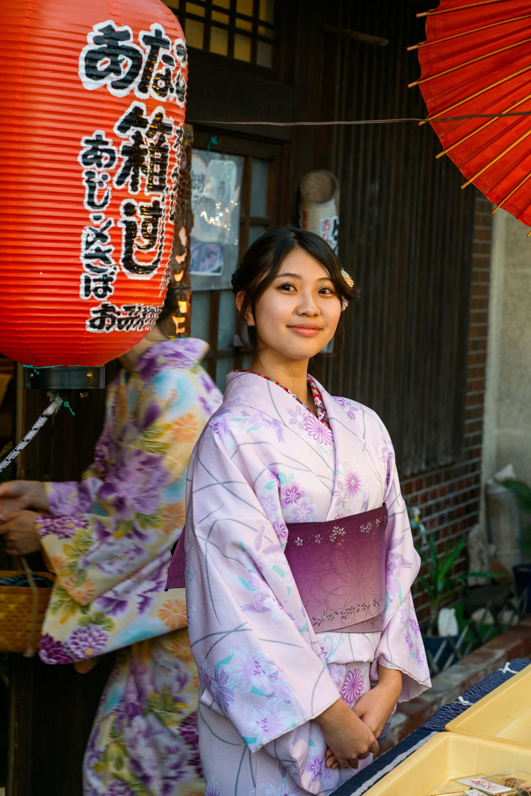 Woman in vibrant colorful furisode kimono with flowing sleeves posing elegantly under cherry blossoms in Kyoto temple garden