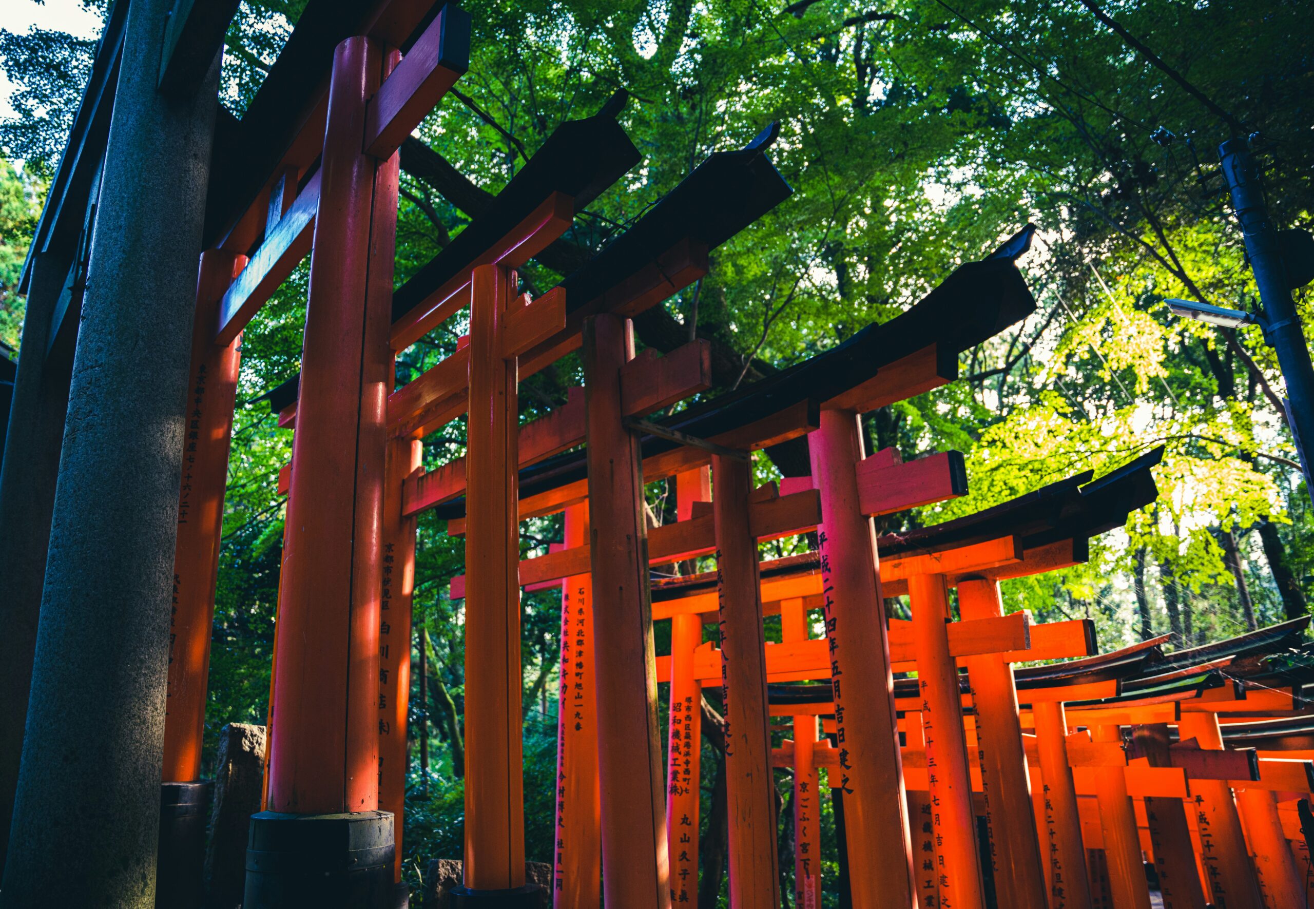 Stone kitsune fox spirit statue at Fushimi Inari Shrine in Kyoto wearing traditional red ceremonial attire, representing Japanese folklore
