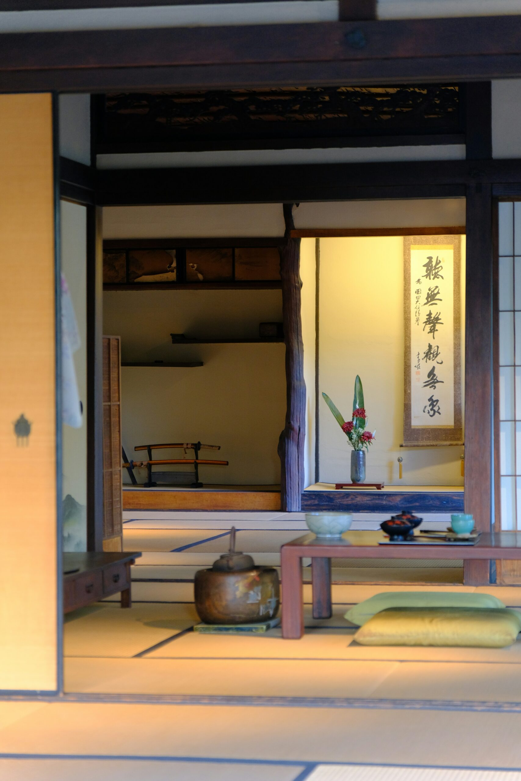 Traditional Japanese tatami room interior with wooden architecture, sliding doors, calligraphy scroll, and ceremonial tea items showcasing authentic kimono photography setting