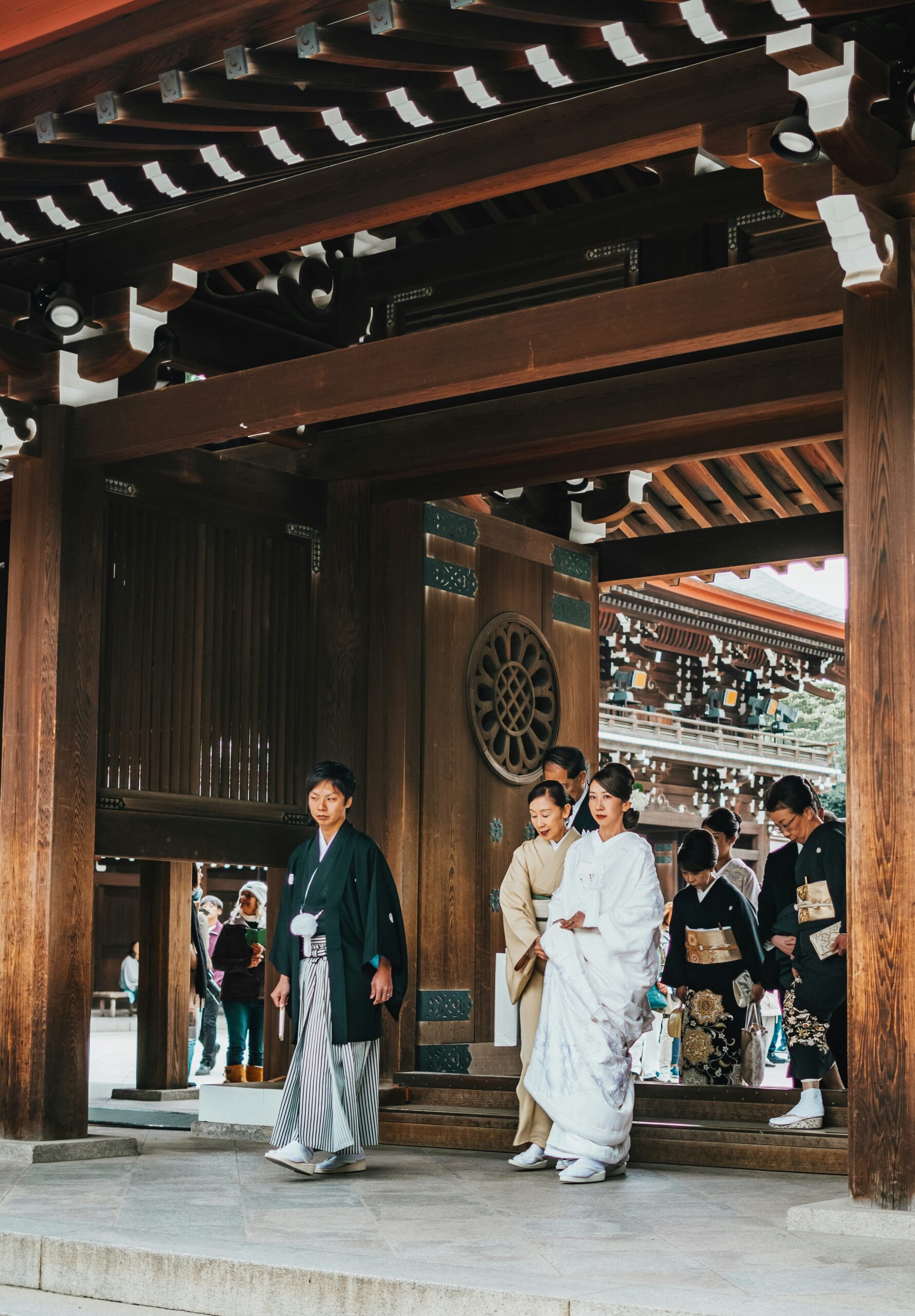 Japanese wedding photography in Kyoto temple grounds with traditional wooden architecture and autumn foliage backdrop