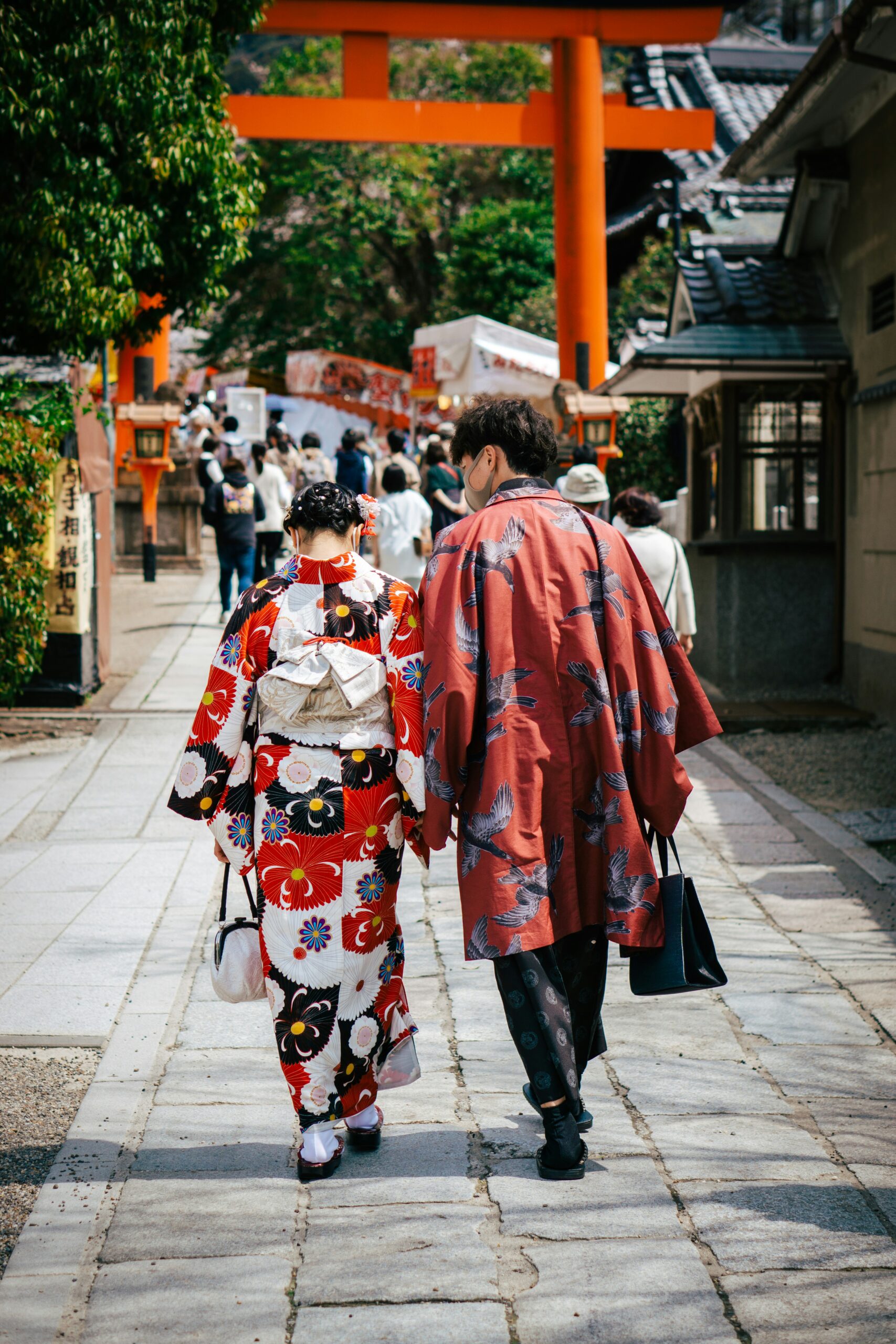 Couple wearing traditional kimono walking through historic Gion district in Kyoto with traditional lanterns and architecture