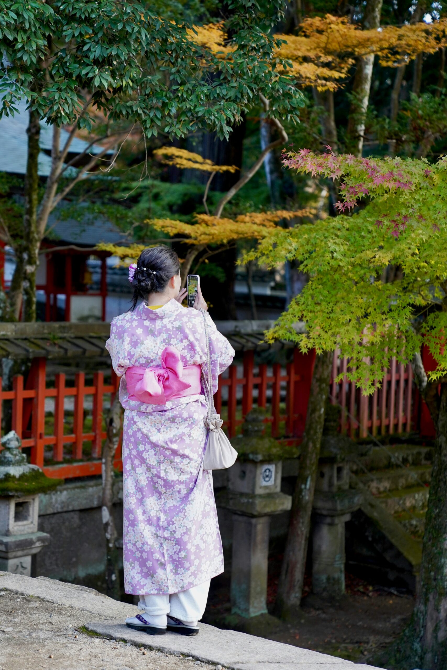 Romantic couple wearing matching kimono walking hand in hand through the famous Arashiyama bamboo grove in Kyoto during professional photography session