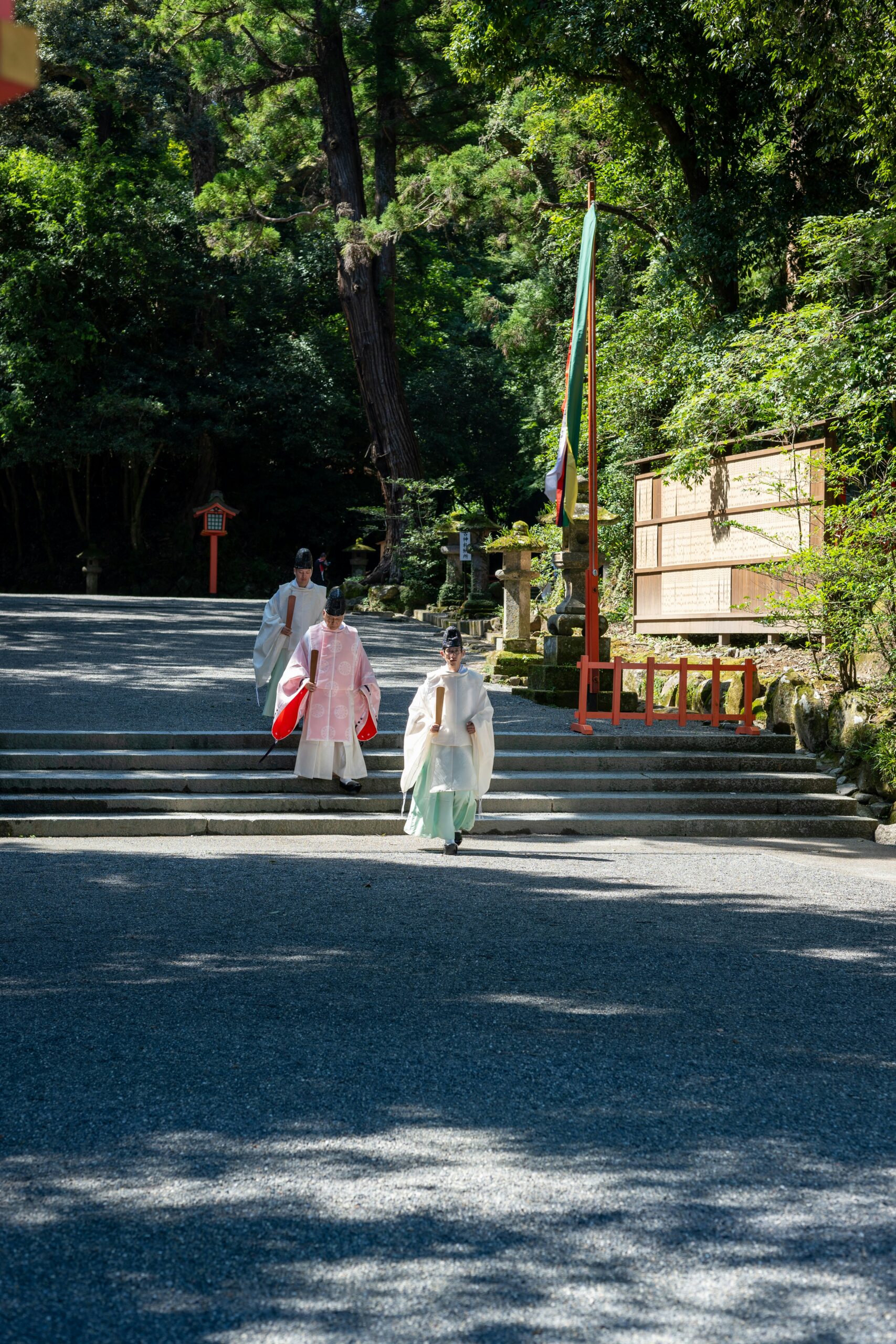Japanese wedding couple in traditional kimono at Heian Shrine gardens in Kyoto, with vermilion gates and serene lake reflecting traditional architecture