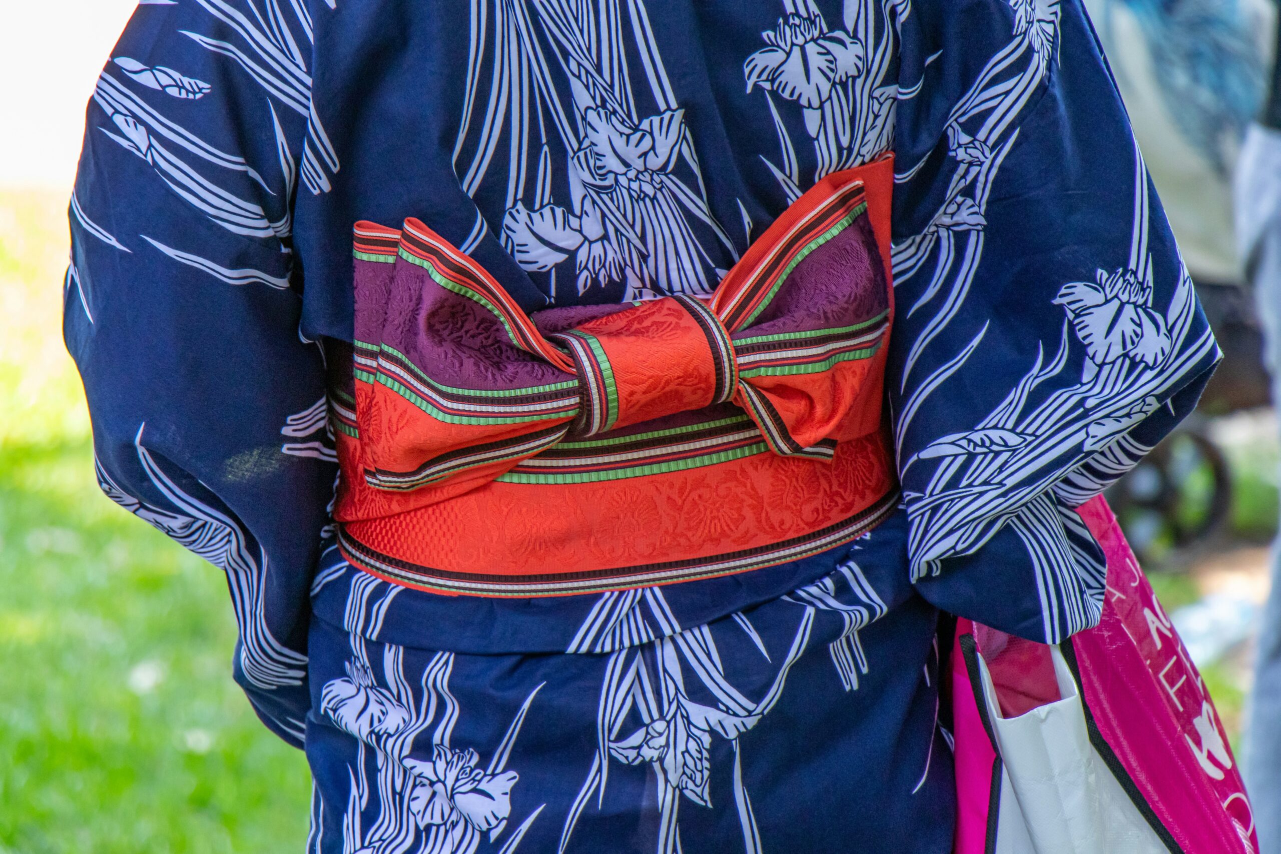 Close-up detail of traditional Japanese kimono embroidery featuring cranes and cherry blossoms, showing intricate metallic thread work symbolizing eternal love and renewal