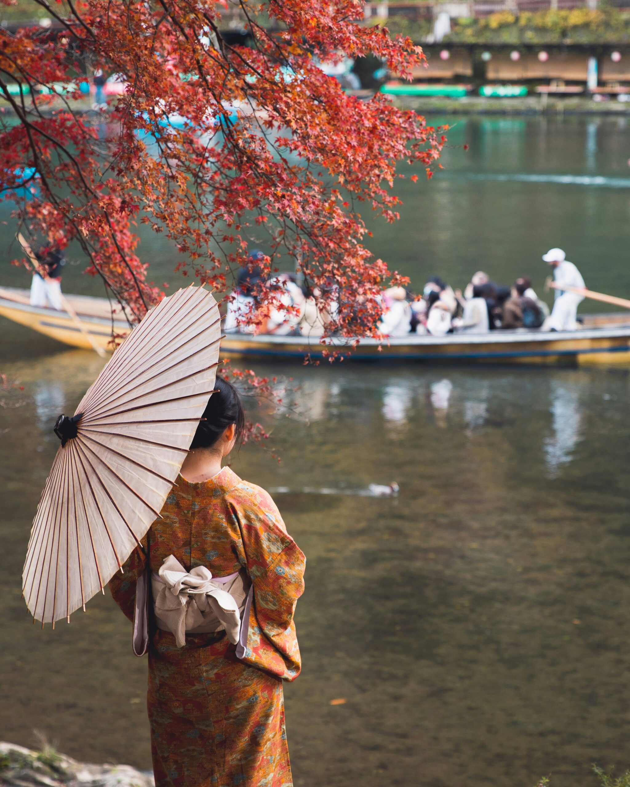 Beautiful woman in traditional colorful kimono enjoying a serene boat ride on Kyoto's historic waterways during a cultural festival recreation