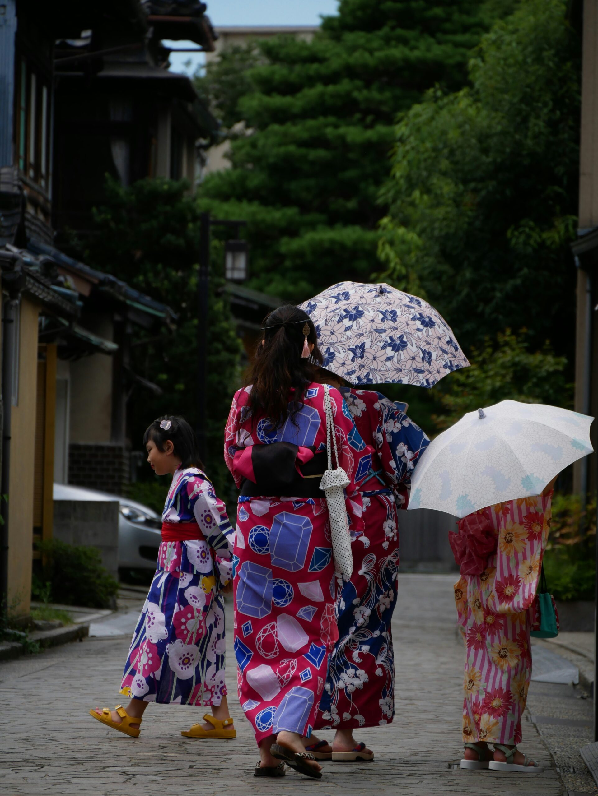 Elegant woman wearing traditional colorful silk kimono walking through historic Gion district in Kyoto, showcasing Japanese cultural fashion and heritage