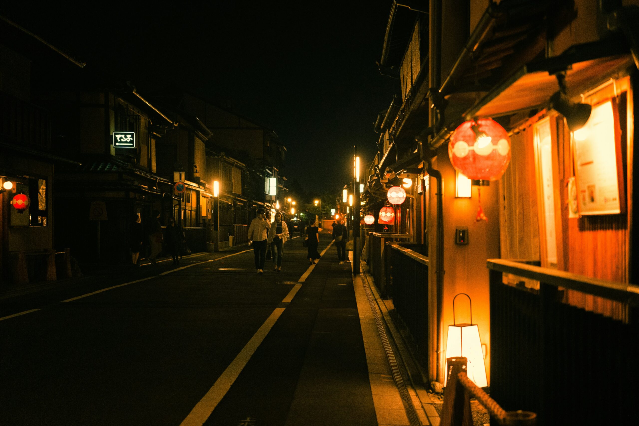 Traditional lantern-lit street in Gion district of Kyoto at night with atmospheric lighting and traditional architecture perfect for kimono photography