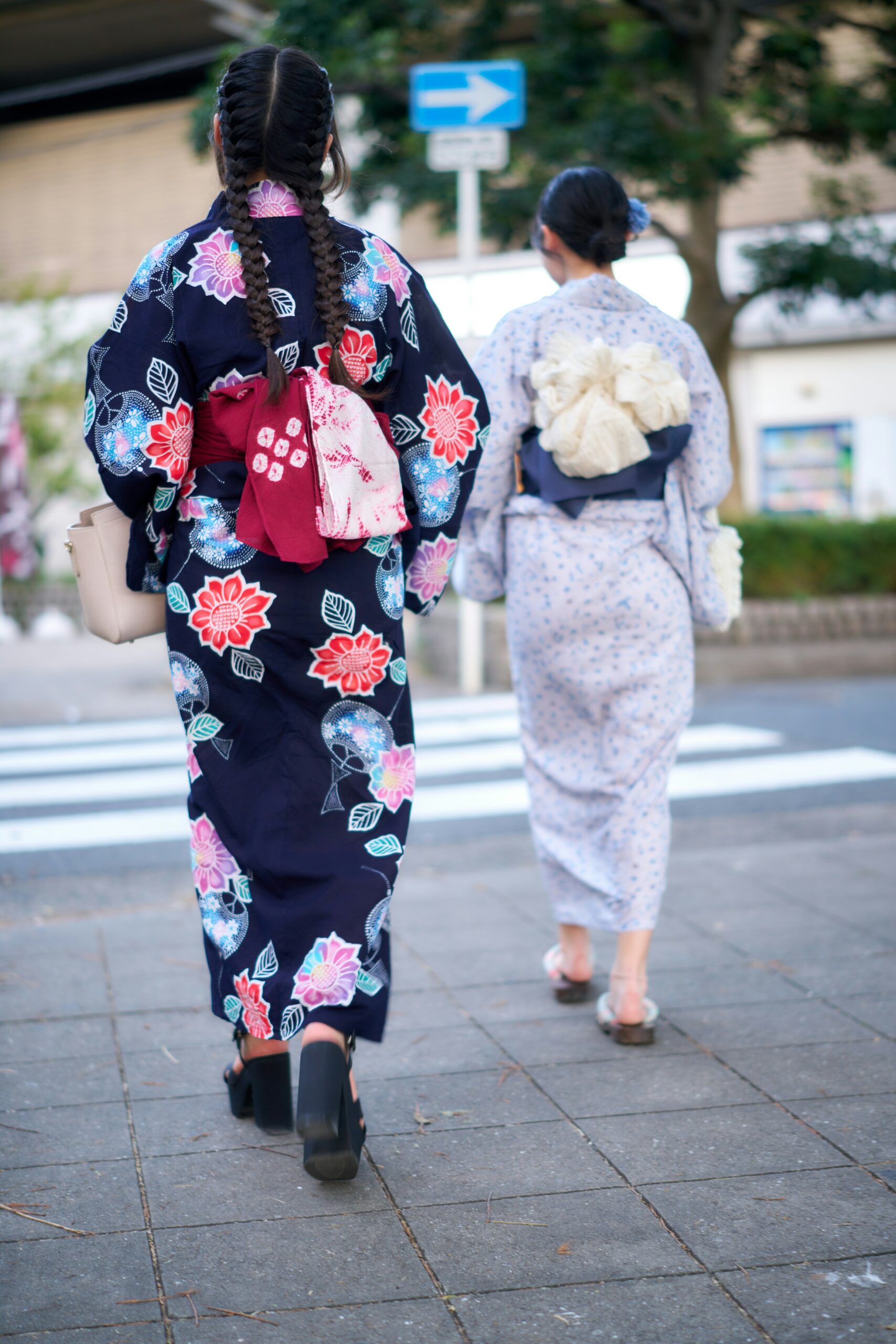 Professional kimono dressing and hair styling service in Kyoto showing traditional Japanese kimono rental preparation process with obi belt tying and hair arrangement