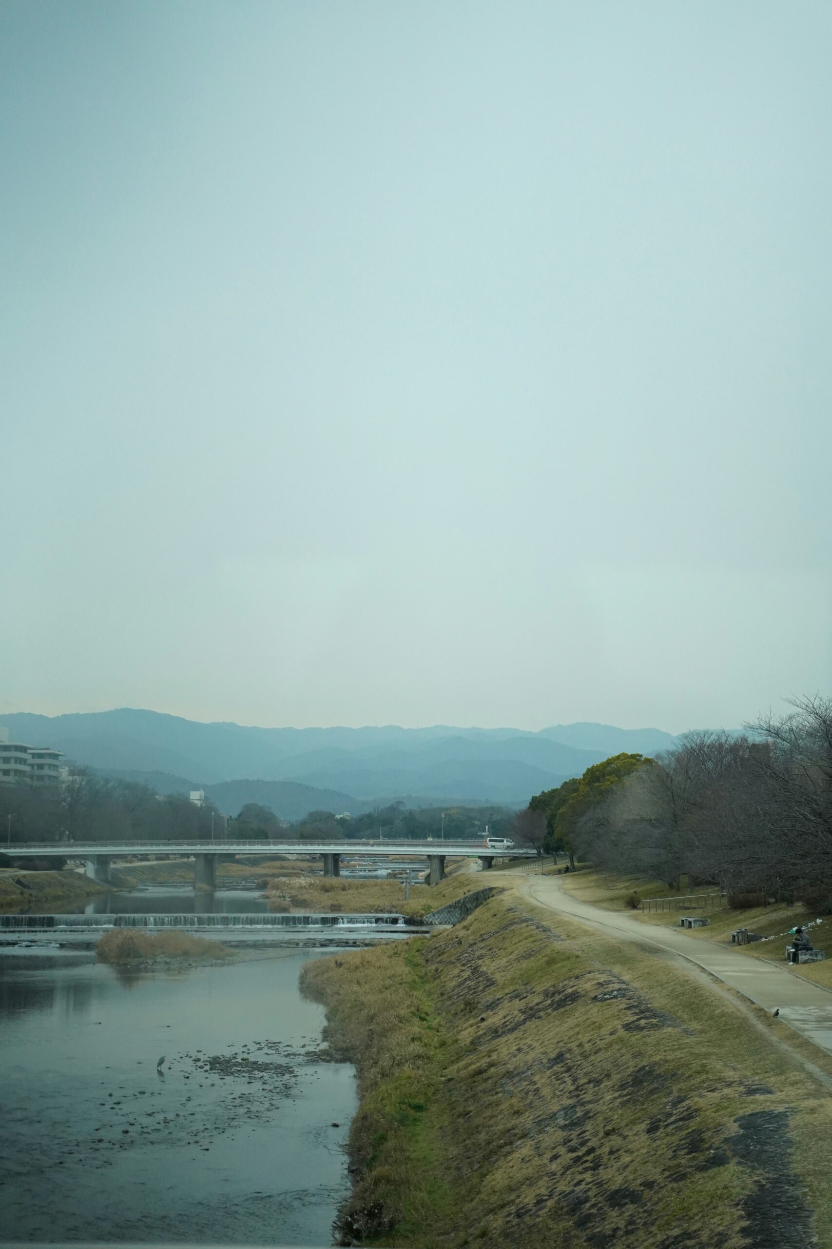 Shijo Bridge over Kamo River in evening Kyoto Japan with illuminated buildings and traditional architecture reflecting on water