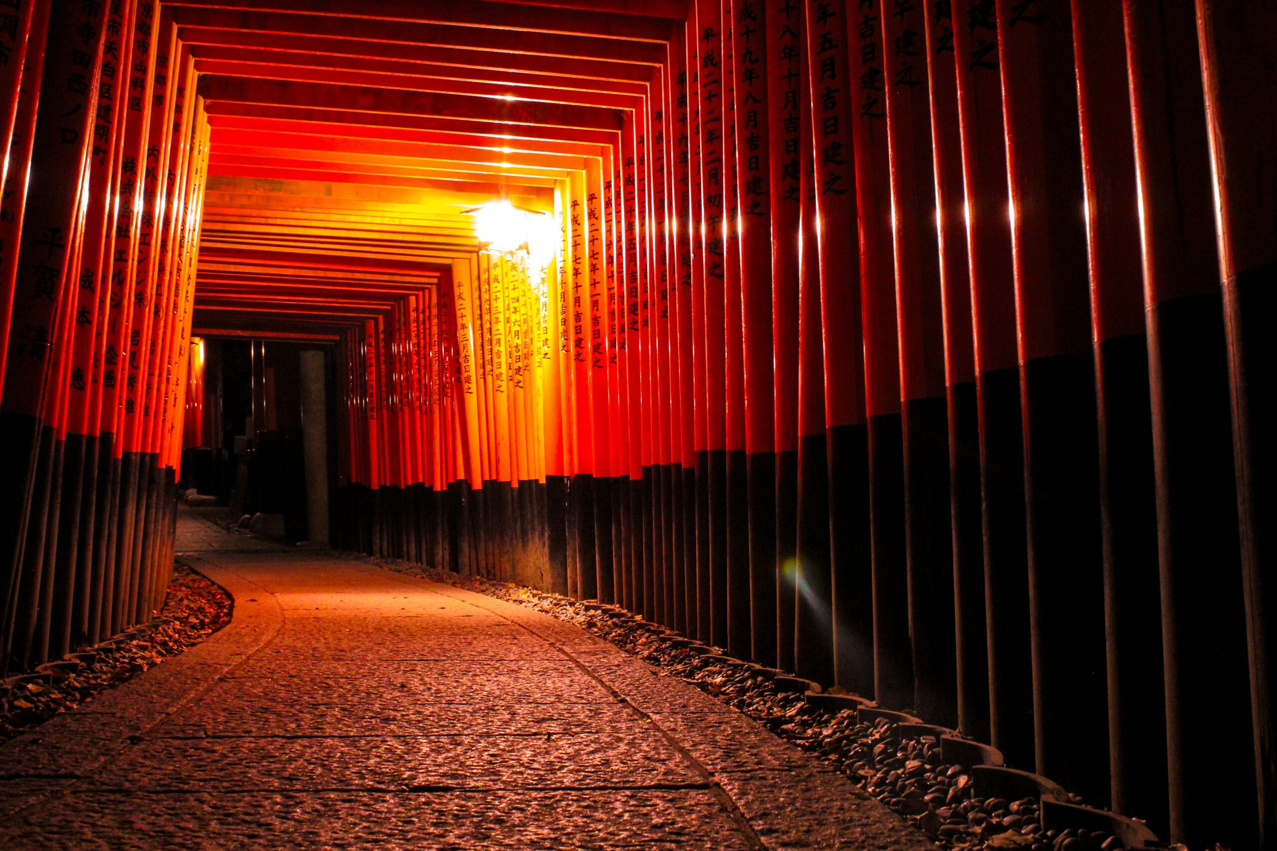 Breathtaking aerial view of Fushimi Inari Shrine showing thousands of torii gates winding up Mount Inari through lush forest canopy in Kyoto