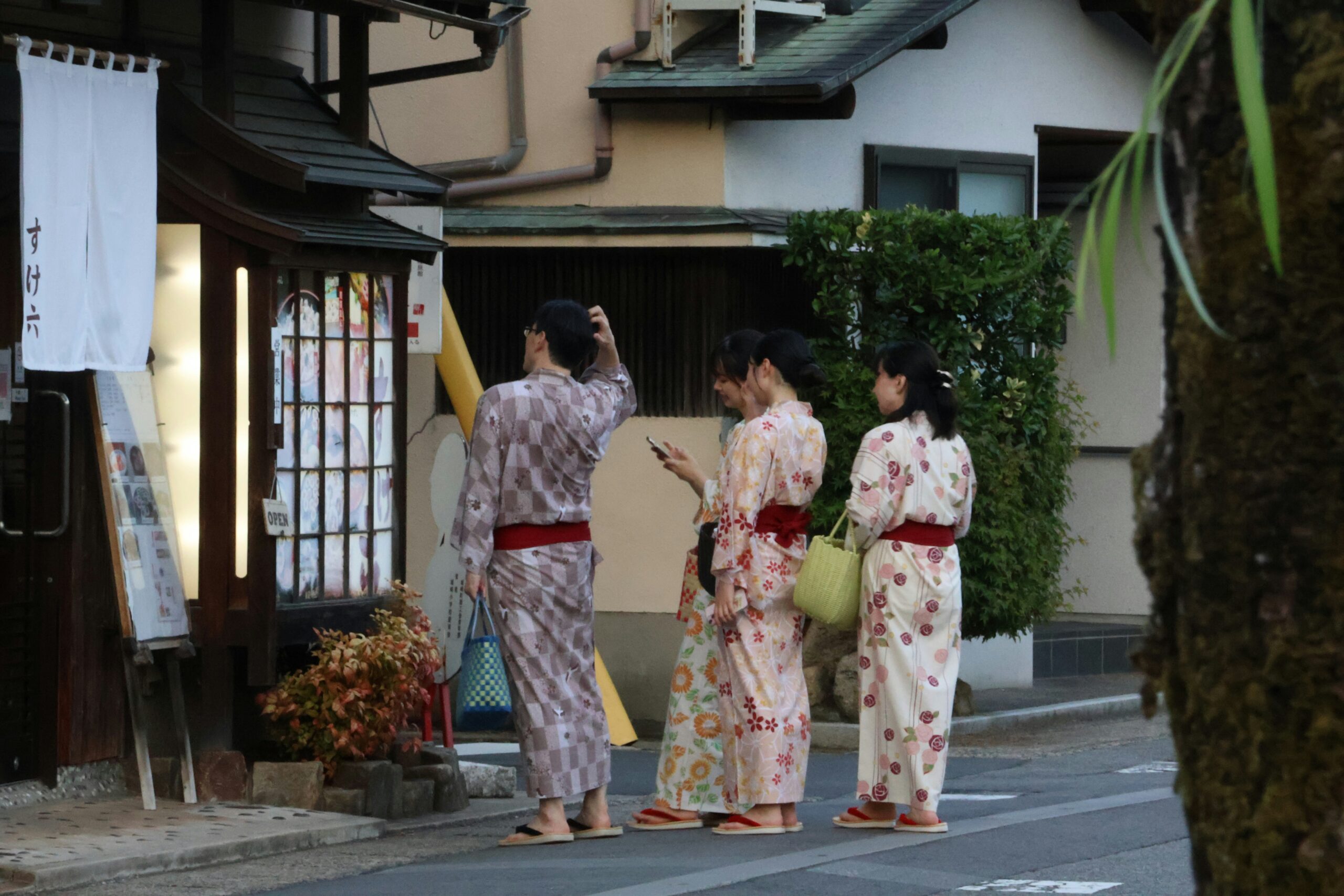 Woman in colorful kimono sitting at traditional Japanese cafe in Kyoto enjoying matcha tea