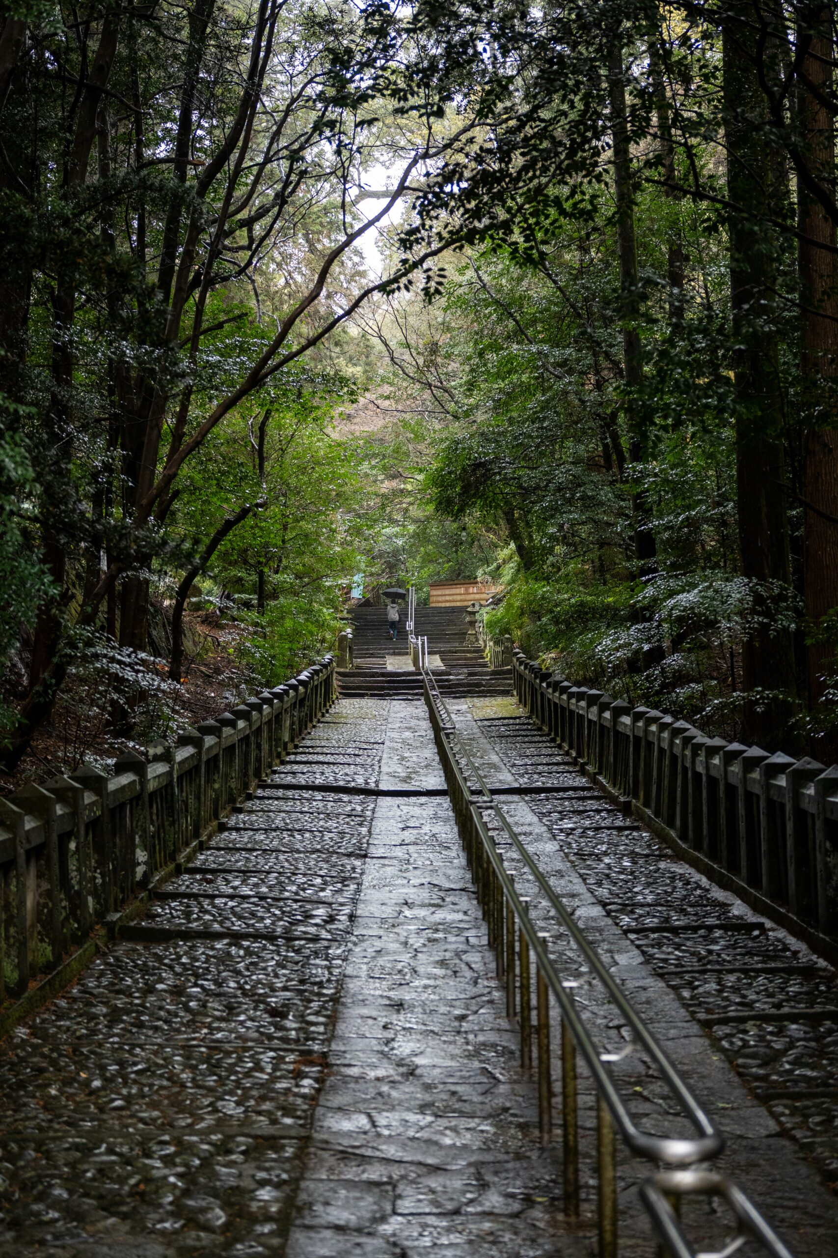 Rainy night in Gion district Kyoto with wet cobblestone streets reflecting traditional lanterns and atmospheric lighting