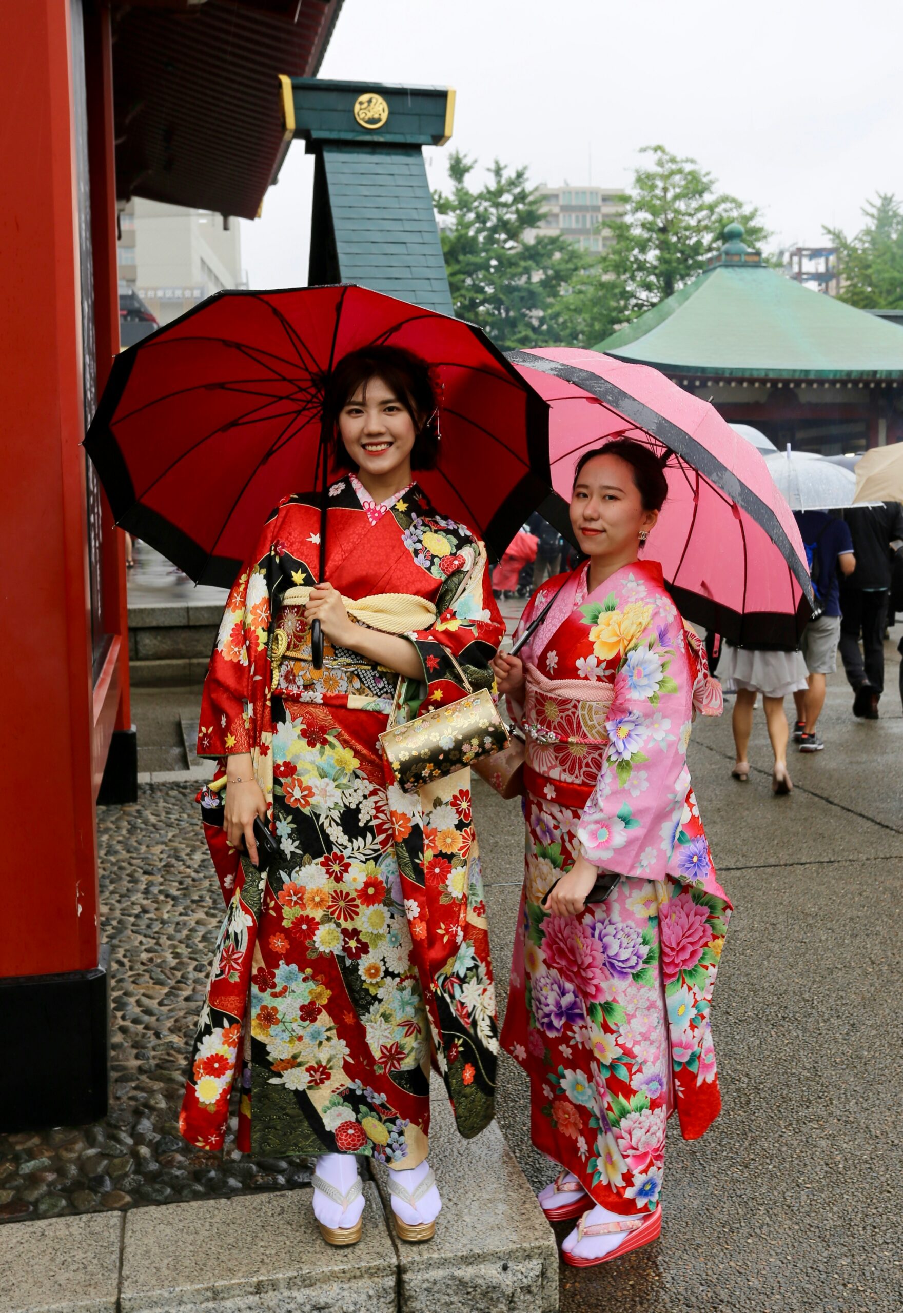 Professional kimono photoshoot in Kyoto Japan with woman in colorful traditional red floral kimono posing at historic temple Japanese cultural experience authentic kimono rental and photography